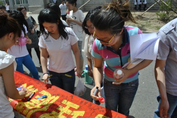 师生们纷纷在条幅上签字